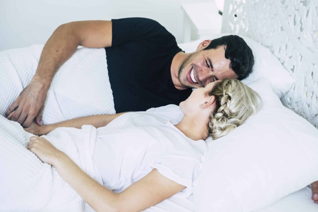 Happy couple of young people in bed enjoy relationship